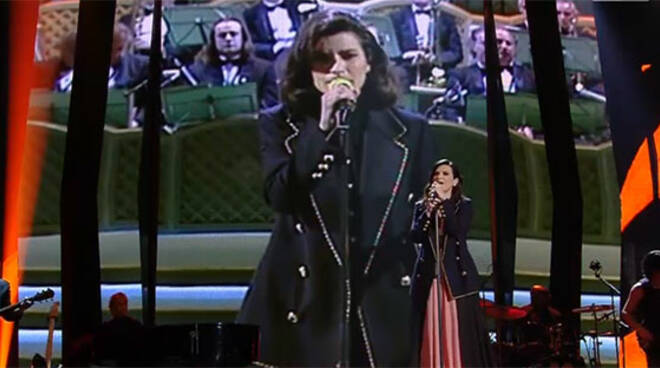 Laura Pausini sul palco dell'Ariston e, alle spalle, la cantante nel 1993