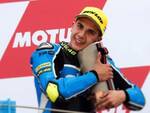 Andrea Migno, 20 anni, sul podio di Assen si coccola il trofeo per il terzo posto nel Gp d'Olanda classe Moto3