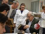 Vittorio Sgarbi osserva alcuni testi antichi sottoposti a restauro nei laboratori di Formula Servizi per la Cultura a Forlì