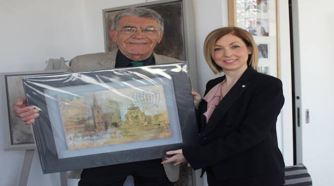 Nell'immagine l'opera firmata da Ido Erani nelle mani dell'artista. Al suo fianco Elena Babini, Presidente Vicario dei Giovani Imprenditori di Confindustria Forlì-Cesena.